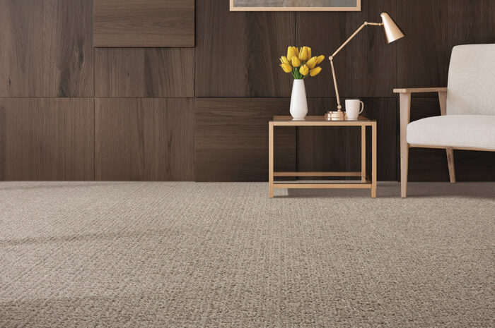 Midcentury modern looking room with light gray carpet, white chair with wood arms, and dark wood wall.