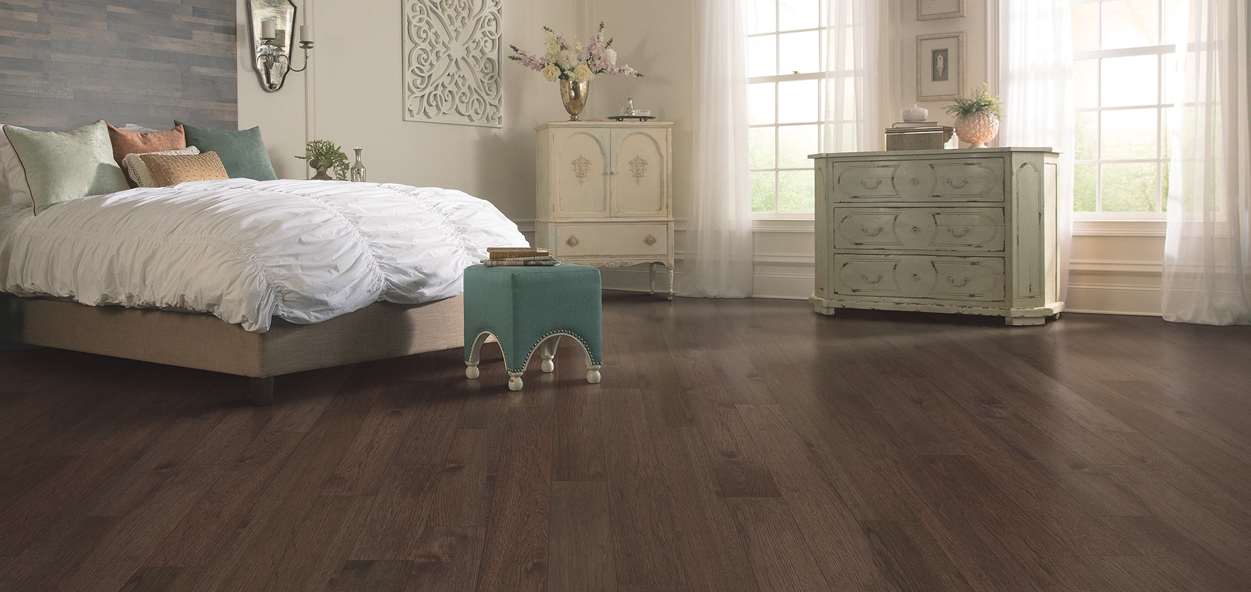 Level view of bedroom white beautiful warm brown hardwood floors.