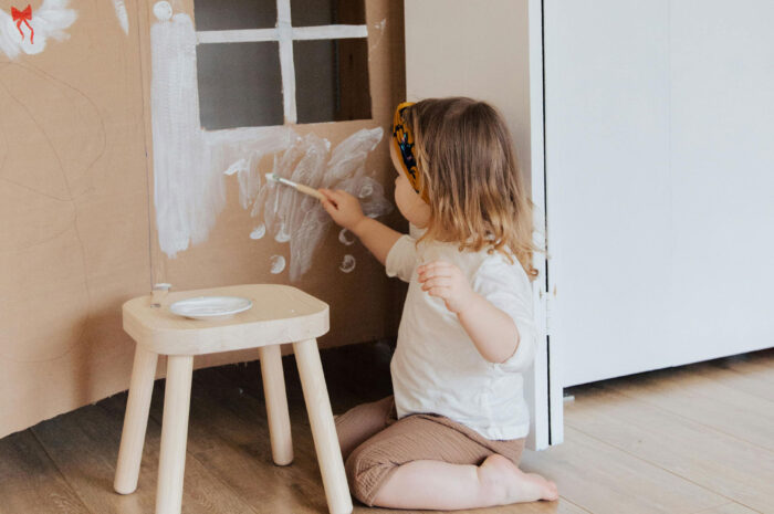 child painting on hardwood floor